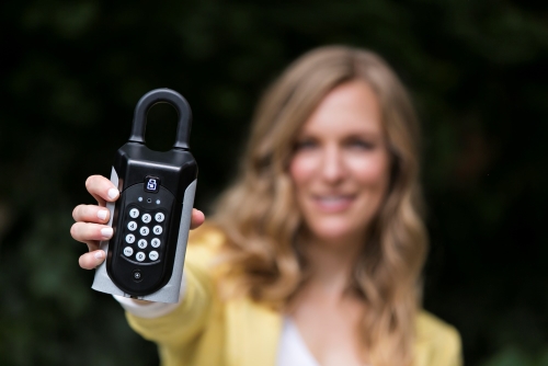 SentriGuard-key-safe-real-estate A real estate agent holding a sentriguard key safe