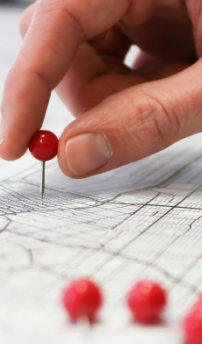 Multiple site access management - a person sticking a pin into a map